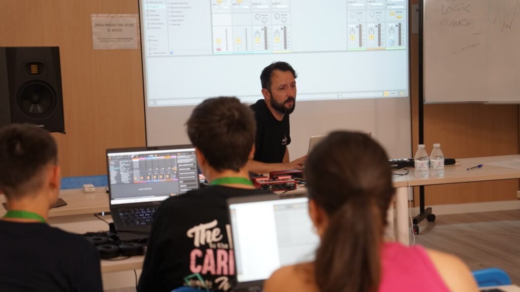 Jóvenes participando en una actividad formativa de producción musical.