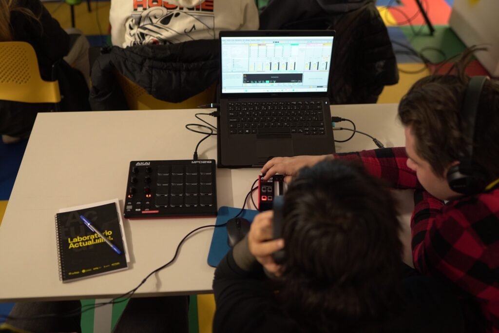 Jóvenes creando música con software y controladores en un taller de producción musical